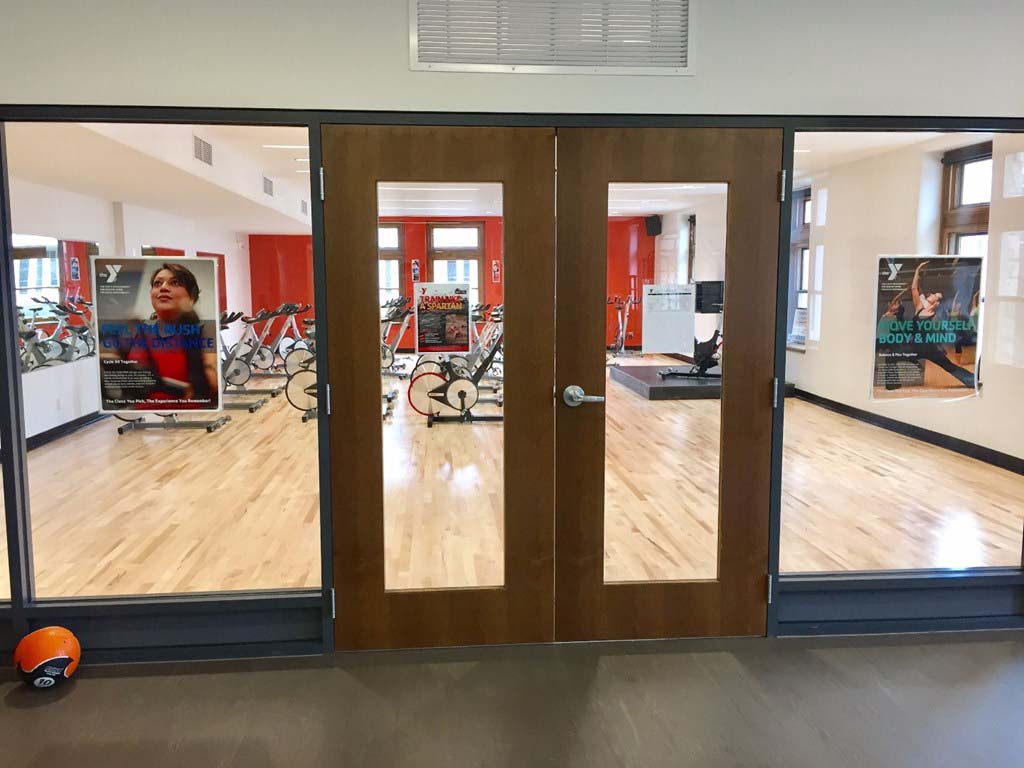 Custom wood door and hollow metal frames leading to fitness center