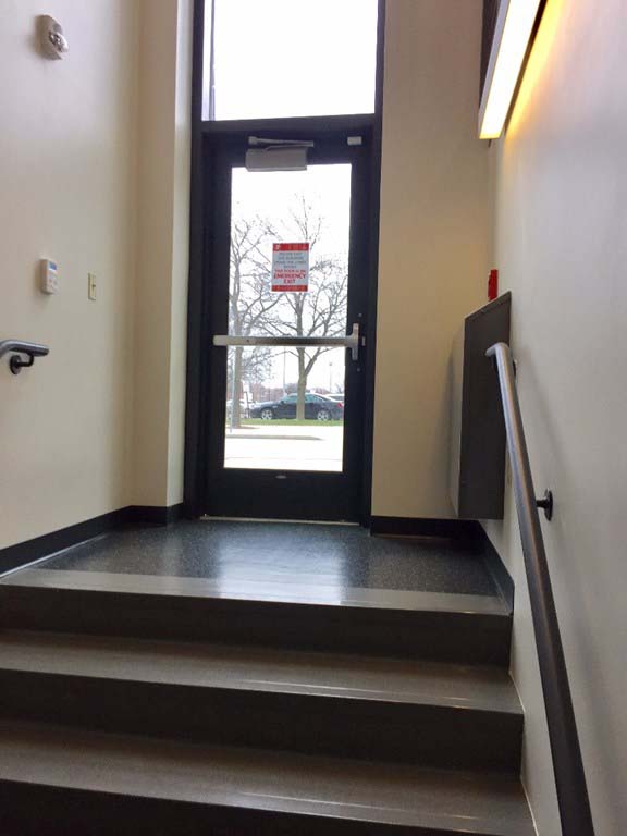 Small stairway leading to a custom hollow metal exit door by LaForce Inc.